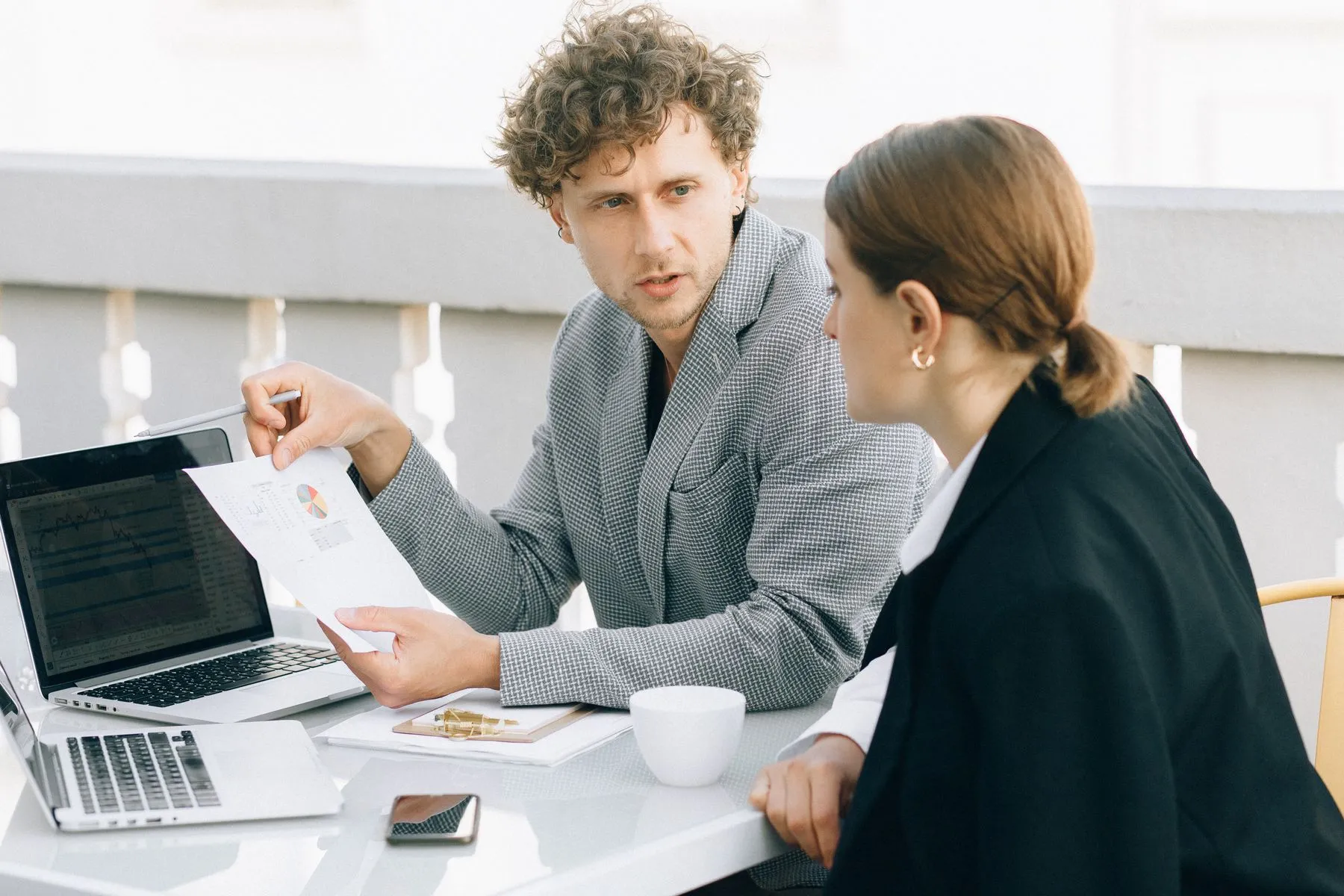 Two professionals reviewing a document together at a laptop